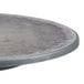 A Grosfillex round table with a grey zinc surface and charcoal metal legs.