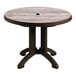 A Grosfillex round resin table with a hole in the middle for an umbrella, on bronze legs.