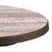 A Grosfillex Aquaba round resin table top with bronze legs.