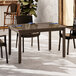 A Grosfillex Sigma bronze aluminum dining table with four chairs.