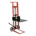 A red and black Wesco Industrial Products hydraulic pedalift with a black table on top.