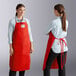 Two women wearing Tucker Safety red aprons in a professional kitchen.