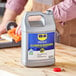 A man using WD-40 Industrial-Strength Cleaner and Degreaser on a wood counter in a professional kitchen.