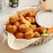 A basket of Beyond Meat plant-based vegan popcorn chicken with a bowl of white sauce.