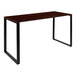 A mahogany desk with black metal legs.