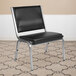 A black Flash Furniture Hercules bariatric reception chair with silver metal legs on a carpet.