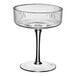 An Acopa Lore coupe glass with a stem on a white surface.