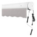 A white awning with a grey shade extended over a window.