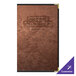 A brown metallic menu cover with black borders on a table.