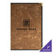 A brown brushed metallic menu cover with black text on a table in a bar.