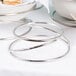 An American Metalcraft stainless steel riser set with a bowl of food on a white table.