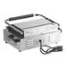 An Avantco commercial panini grill with grooved and smooth rectangular metal plates and black handles.