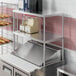 An Avantco stainless steel double deck overshelf with food on it.
