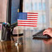 A Valley Forge United States stick flag on a desk.