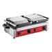 An Avantco commercial dual panini grill with red and black plates on a table.