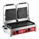 An Avantco commercial dual panini sandwich grill on a table with two black rectangular plates.