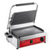 An Avantco commercial panini grill with a red and black handle and smooth plates.