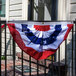 A Valley Forge United States flag hanging from a railing.