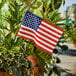 A Valley Forge United States of America stick flag planted in a pot.