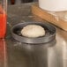 A dough ball on an American Metalcraft hard coat anodized aluminum pizza pan.