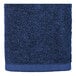 A close up of a navy blue hand towel with a white border.