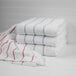 A stack of white towels with blue stripes.