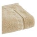 A beige 1888 Mills bath mat with a white border.