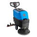 A blue and black Lavex walk behind floor scrubber machine with wheels and a handle.