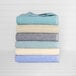 A stack of folded teal pool towels with a white border.