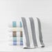 A stack of gray striped 1888 Mills Fibertone Cabana pool towels on a shelf.