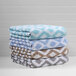 A stack of gray and white diamond patterned Fibertone pool towels.