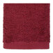 A close up of a red 1888 Mills hand towel with a white background.