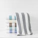 A stack of blue striped 1888 Mills Fibertone pool towels on a shelf.