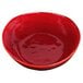 A red bowl with an irregular shape and reactive glaze finish on a white background.