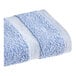 A blue 1888 Mills Fibertone hand towel with two white stripes.