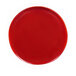 A red plate with a reactive glaze finish on a white background.