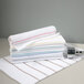 A stack of 1888 Mills Fibertone gray stripe pool towels on a table.