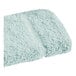 A seafoam green Fibertone washcloth with a fluffy texture.