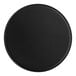 A black round vinyl coaster on a table.