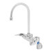 A silver T&S wall mount faucet with a blue handle and a swivel gooseneck.