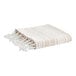 A white blanket with tan stripes and fringes.