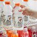 A person holding a close-up of a red Gatorade Frost Glacier Cherry sports drink bottle.