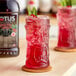 A glass of Lotus Plant Energy Ruby Red Cascara.