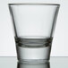 A close up of a clear Libbey shot glass with a half empty rim.