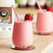 Lotus Plant Energy Original Vanilla Oat Cream Base 3:1 Concentrate in a glass of pink drink with a straw.