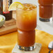 A glass of SHOTT iced tea with a lemon wedge on the rim.