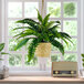 A close-up of a 30" artificial Boston fern in a hanging basket.