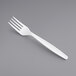 A pack of white plastic forks on a gray background.
