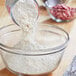 A person pouring ADM Pastry Flour into a glass bowl.