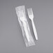 A white heavy weight plastic fork in plastic wrap.